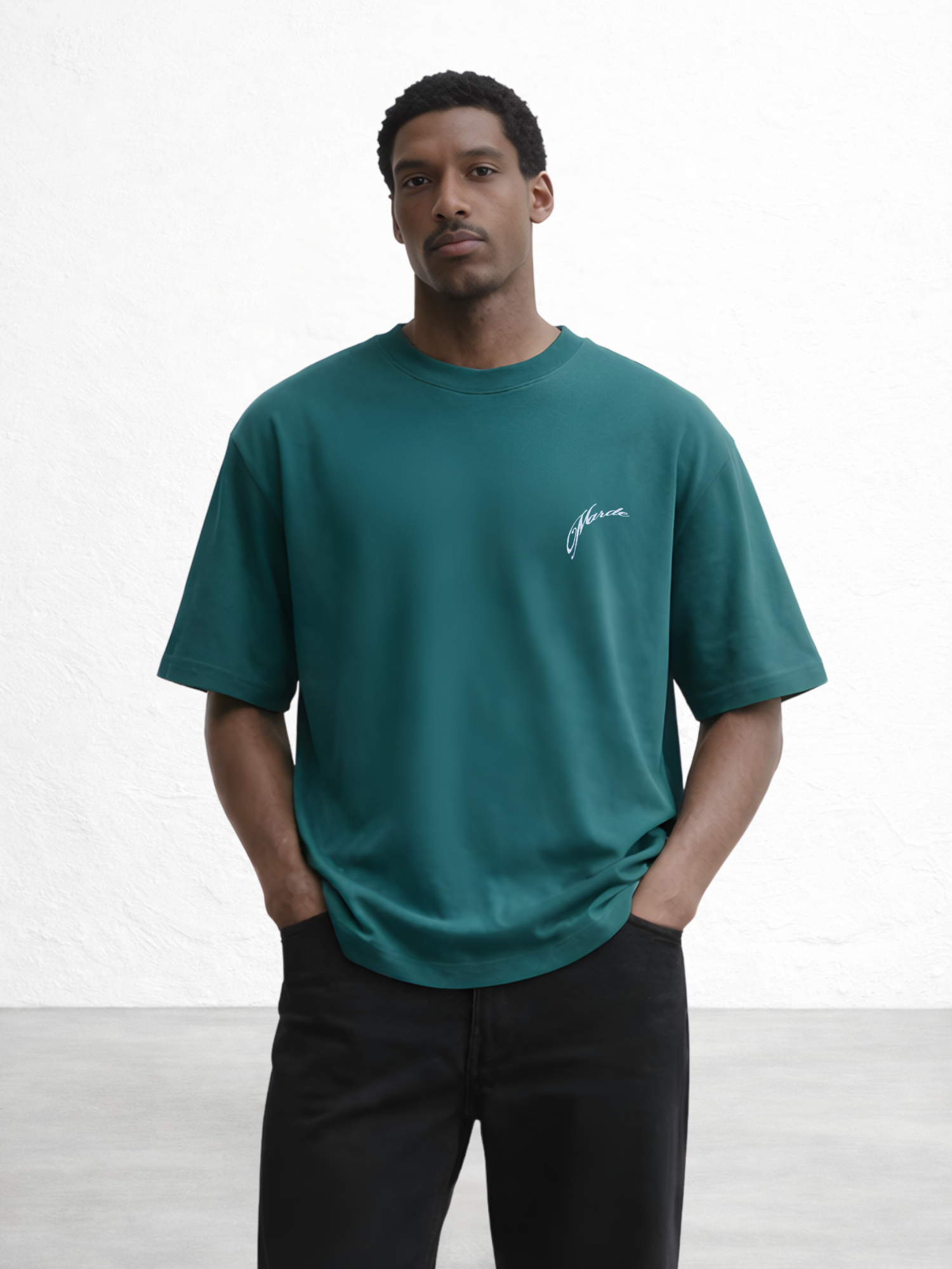 Man wearing a teal t-shirt with a logo on a white background
