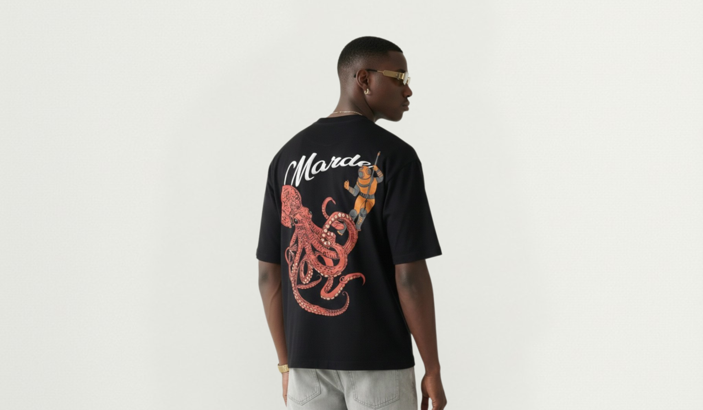 Person wearing a black t-shirt with a colorful design on the back, standing against a plain background.